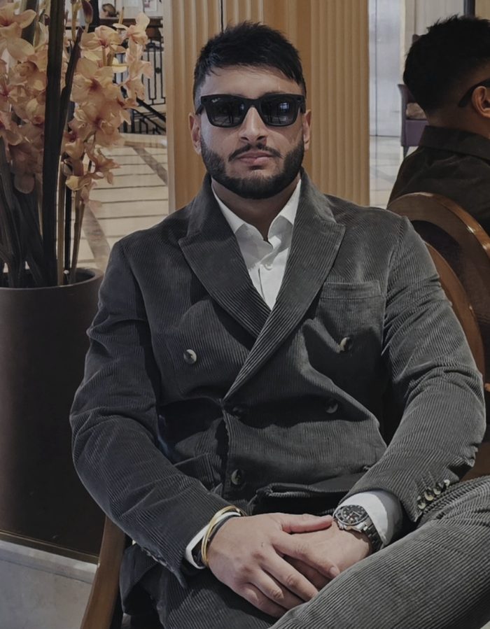 DJ Jeevz in a corduroy suit in a hotel lobby