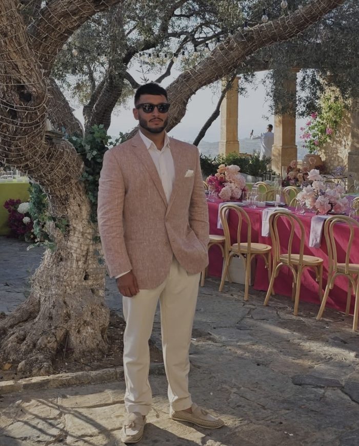 DJ Jeevz at an outdoor wedding venue beneath an olive tree